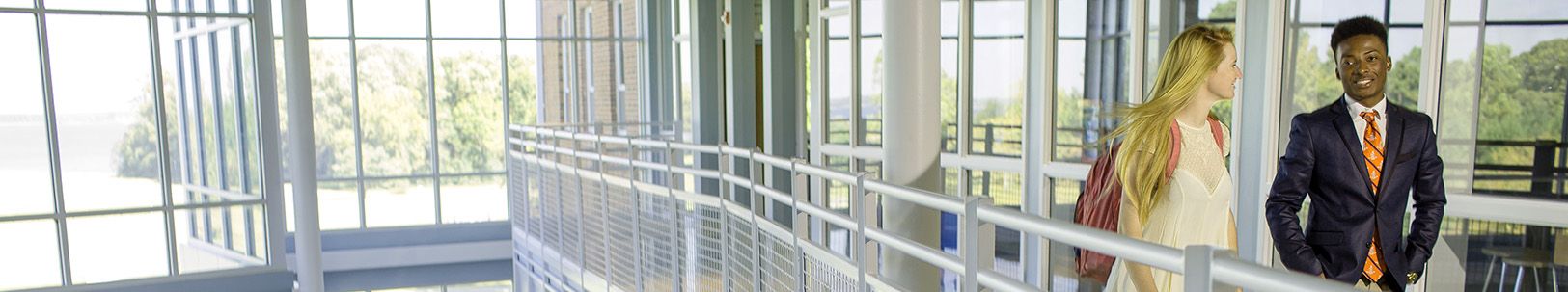 Private boarding school students wearing traditional college prep school dress walking through modern science center